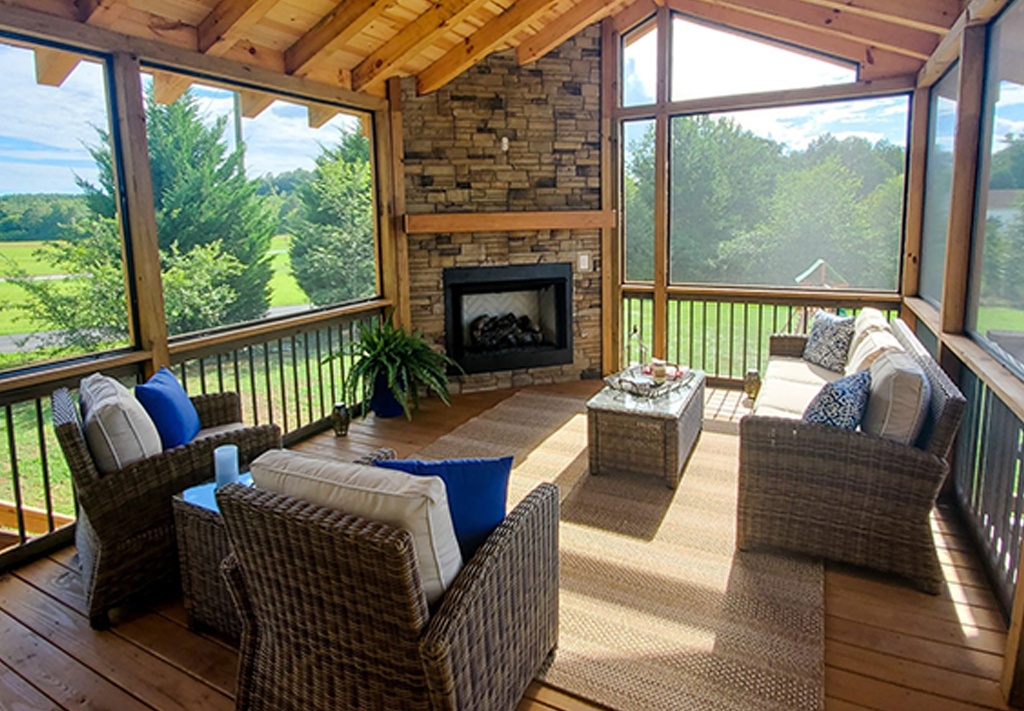 Screened porch with black aluminum balusters, gray composite floor and wind chimes facing the woods